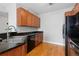 Modern kitchen with dark countertops, wooden cabinets, a double sink, and black appliances at 9019 E Panorama Cir # D418, Englewood, CO 80112