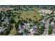 An aerial view of neighborhood homes near a school and green space featuring trees and a playground at 7296 S Flower St, Littleton, CO 80128
