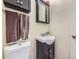 Compact bathroom with dark cabinetry, a small sink, and decorative towels, providing a clean and functional space at 7296 S Flower St, Littleton, CO 80128