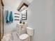 Charming bathroom features a vintage vanity, a toilet, light fixtures, and teal towels at 7296 S Flower St, Littleton, CO 80128
