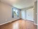 Bright bedroom featuring wood floors, closet space, and a window with neighborhood views at 7296 S Flower St, Littleton, CO 80128