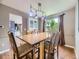 Elegant dining room featuring a large window, wood floors, and a decorative chandelier with seating for six at 7296 S Flower St, Littleton, CO 80128