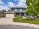 Charming two-story home featuring a well-manicured lawn, brick accents, and a two-car garage at 7296 S Flower St, Littleton, CO 80128