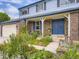 Detailed view of home's front entrance, showcasing the garden, brickwork and front porch seating at 7296 S Flower St, Littleton, CO 80128