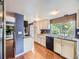Spacious kitchen with white cabinets, hardwood floors, and views of the backyard, offering ample workspace at 7296 S Flower St, Littleton, CO 80128