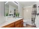 Bright bathroom with wood cabinets, a large mirror, and a shower-tub combo at 828 Rabbit Run Dr, Golden, CO 80401