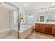 Bright bathroom with a soaking tub, separate shower, and wood cabinets at 828 Rabbit Run Dr, Golden, CO 80401