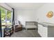 Cozy Bedroom featuring a crib, comfortable armchair, and large window at 828 Rabbit Run Dr, Golden, CO 80401