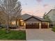 Charming home exterior with stone accents, a well-manicured lawn, and an inviting two-car garage at 828 Rabbit Run Dr, Golden, CO 80401