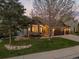 Charming home with stone accents, large windows, a manicured lawn, and rock landscaping features at 828 Rabbit Run Dr, Golden, CO 80401