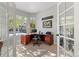 Well-lit home office with large windows, a classic wood desk, and neutral decor for a productive atmosphere at 828 Rabbit Run Dr, Golden, CO 80401