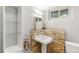 Small basement bathroom with pedestal sink, stone wall and glass shelving at 840 S Gaylord St, Denver, CO 80209