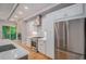 Modern kitchen boasts stainless steel appliances, white cabinets, and a view of the cozy living room at 2831 W 25Th Ave # 3, Denver, CO 80211