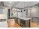 Spacious kitchen island with stainless steel microwave and sink, pendant lights, and hardwood floors at 2831 W 25Th Ave # 3, Denver, CO 80211