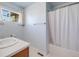Bathroom with a single sink vanity and shower/tub combo with white shower curtain and window at 20592 E Lake Ave, Centennial, CO 80016