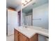 A bathroom with a single sink vanity, mirror, and shower/tub combo with white shower curtain at 20592 E Lake Ave, Centennial, CO 80016