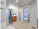 Bathroom with tiled floor, vanity, glass door shower, and doorway to the main bedroom at 20592 E Lake Ave, Centennial, CO 80016