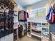 The walk-in closet has built in shelves for organization and a window for natural light at 20592 E Lake Ave, Centennial, CO 80016