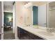Spacious bathroom with double vanity, large mirror, and views into the adjacent room at 15314 W Baker Ave, Lakewood, CO 80228