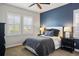 Cozy bedroom featuring accent wall, two windows with shutters, and ceiling fan at 15314 W Baker Ave, Lakewood, CO 80228