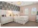Bright bedroom featuring floral wallpaper, arched windows with shutters, and a comfortable bed at 15314 W Baker Ave, Lakewood, CO 80228