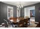 Dining room with wood table, chandelier, dark walls, and an adjacent room with natural light at 15314 W Baker Ave, Lakewood, CO 80228