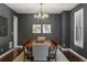Contemporary dining room with dark walls, wood table, chandelier, and elegant wall art at 15314 W Baker Ave, Lakewood, CO 80228