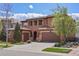Exterior view of a two-story home with a two-car garage, red tile roof, arched entry, and a manicured lawn at 15314 W Baker Ave, Lakewood, CO 80228