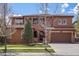 Two-story home featuring a red tiled roof, arched entry, two-car garage and a well-maintained lawn at 15314 W Baker Ave, Lakewood, CO 80228