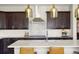 Modern kitchen features a large island, stainless steel hood, and stylish pendant lights at 15314 W Baker Ave, Lakewood, CO 80228