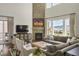 Bright living room with stone fireplace, plush seating, large windows, and mountain views at 15314 W Baker Ave, Lakewood, CO 80228