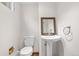 Well-lit bathroom includes a pedestal sink, modern mirror, and a tile floor at 3194 S Milwaukee St, Denver, CO 80210