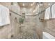 Bathroom displaying stone tile shower, glass enclosure, pebble floor and neutral walls at 3194 S Milwaukee St, Denver, CO 80210