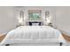 Comfortable bedroom showcases a soft white comforter, wood floors, and matching bedside tables at 3194 S Milwaukee St, Denver, CO 80210