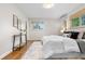 Bedroom boasts a plush rug, neutral walls, wood floors, and a comfy white comforter at 3194 S Milwaukee St, Denver, CO 80210