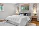 Cozy bedroom featuring a plush white comforter, wood nightstands and neutral decor at 3194 S Milwaukee St, Denver, CO 80210