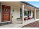 Inviting front porch features decorative door, seating area, and brick exterior for a cozy welcome at 3194 S Milwaukee St, Denver, CO 80210