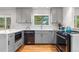 Bright kitchen features gray cabinets, modern appliances, and a window overlooking the backyard at 3194 S Milwaukee St, Denver, CO 80210