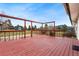 Back deck with red wood, wooden railings, and a view of the property and surrounding landscape at 5128 S Greenwood Dr, Evergreen, CO 80439