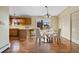 Charming dining area featuring hardwood floors and a kitchen with barstool seating at 5128 S Greenwood Dr, Evergreen, CO 80439