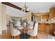 Dining area with a glass table, modern chairs, and hardwood floors open to the kitchen at 5128 S Greenwood Dr, Evergreen, CO 80439