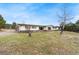 Ranch home with beige siding, a green lawn, and mature trees at 5128 S Greenwood Dr, Evergreen, CO 80439