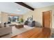 Cozy living room with exposed beam, large window, and comfortable seating arrangement at 5128 S Greenwood Dr, Evergreen, CO 80439