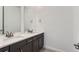 Bathroom with double vanity, quartz countertop, and dark brown cabinets at 15566 W Beloit Ave, Morrison, CO 80465