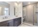 Main bathroom with double vanity, quartz countertop, and a large walk-in shower at 15566 W Beloit Ave, Morrison, CO 80465