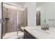 Bathroom with a walk-in shower, quartz countertop, and dark brown cabinets at 15566 W Beloit Ave, Morrison, CO 80465