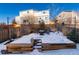 Snowy backyard patio with seating area and fire pit at 1728 Valley Oak Ct, Castle Rock, CO 80104