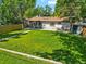 Lush backyard with a well-manicured lawn and mature trees, ideal for outdoor entertaining at 4140 S Inca St, Englewood, CO 80110