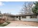 A single story home features brick driveway leading to a two-car garage and a well maintained lawn at 13969 W 23Rd Ave, Golden, CO 80401