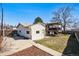 The back of the house features a back deck with a pergola and a detached garage and a mix of gravel and grass yard at 7815 Conifer Rd, Denver, CO 80221